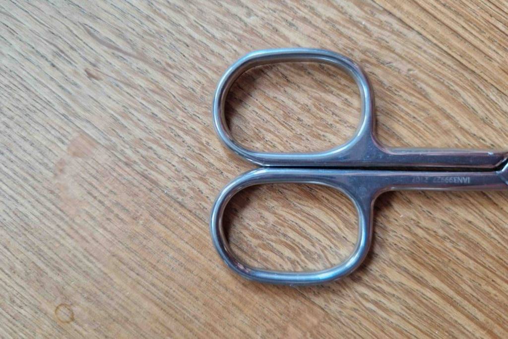 Nagelschere-Test: Nagelschere auf Holzfläche - Fingerlöcher in Nahaufnahme.