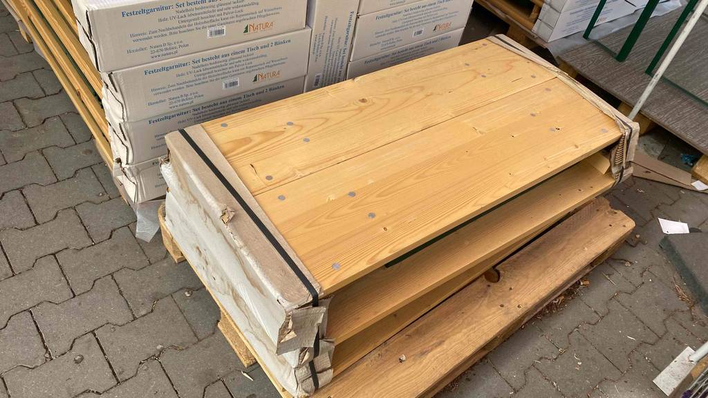 Bierzeltgarnitur im Test: eine noch nicht zusammengebaute Bierzeltgarnitur liegt in einem Geschäft auf einer Palette.