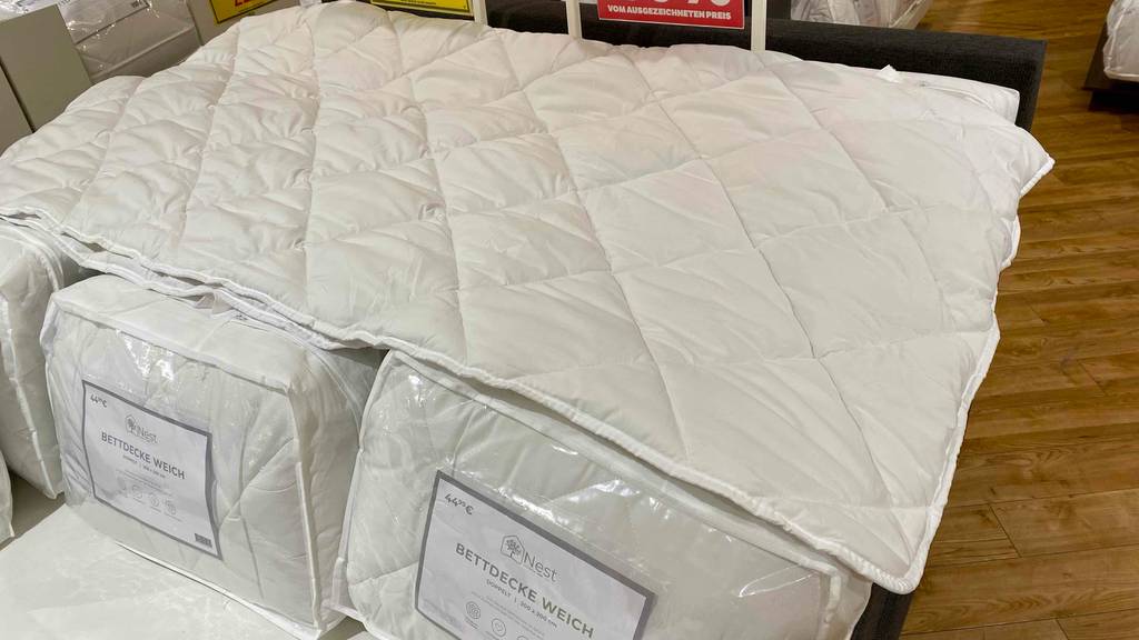 Im Test: Eine ausgebreitetete Bettdecke 200 x 200 liegt über mehreren Verpackten.