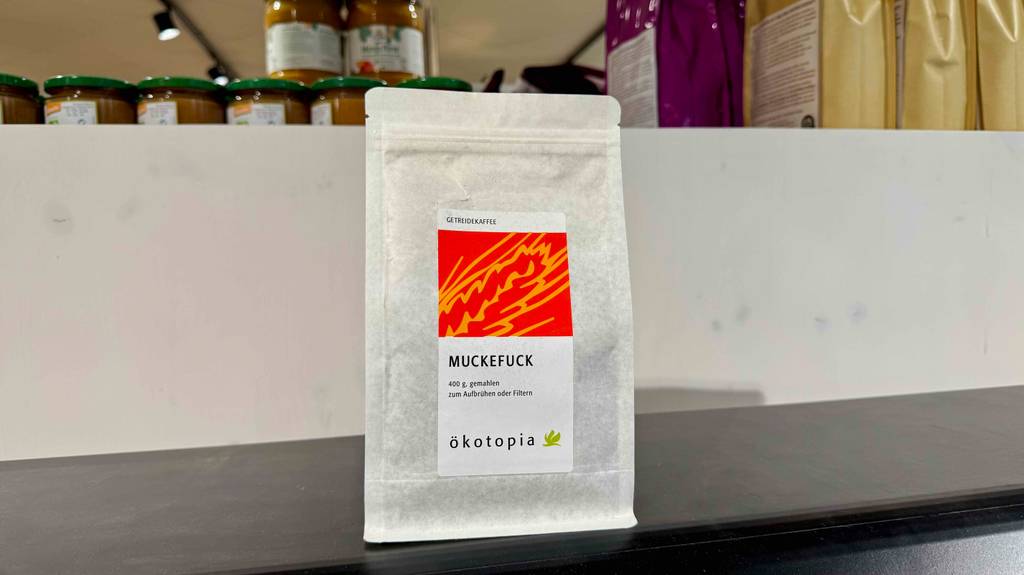 Die wiederverschließbare Papiertüte mit dem Getreidekaffee im Test steht auf einem Regal im Verkaufsbereich.