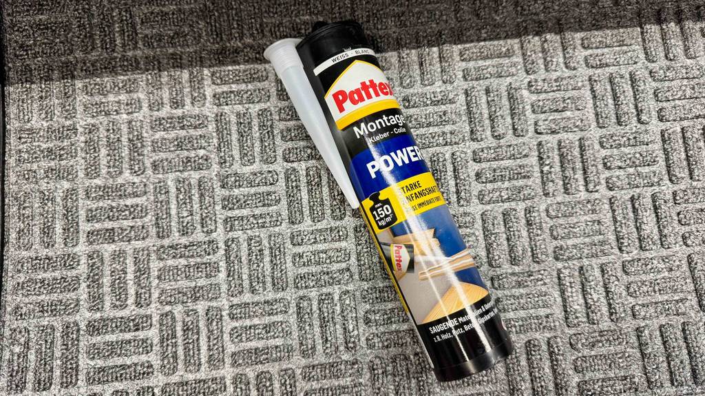 Test: Ein Pattex-Kleber liegt auf einem grauen Teppich.
