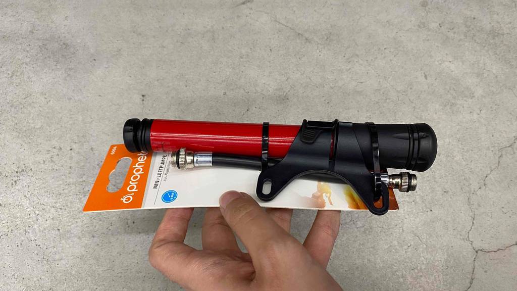 Minipumpe-Test: rot-schwarze Minipumpe in Verpackung wird in der Hand gehalten.