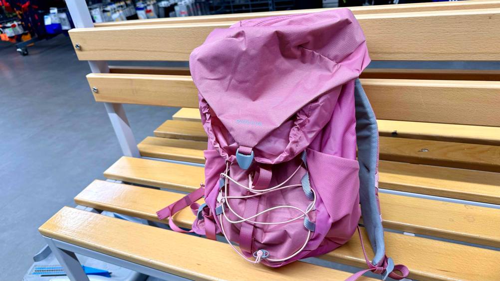 Der getestete Kinder-Wanderrucksack in der Farbe Pink ist auf einer Sitzbank platziert.