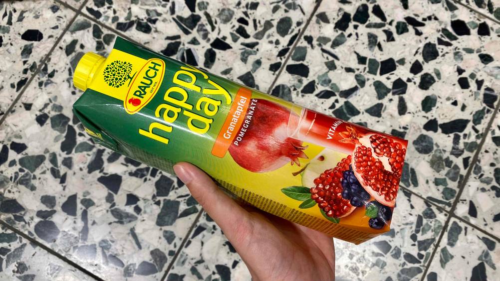 Granatapfelsaft getestet: Hand hält einen Tetrapack