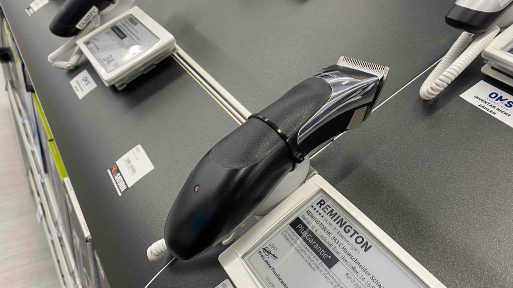 Im Test: Auf einer grauen Fläche befindet sich in einer Halterung ein Remington-Haarschneider von der Seite.