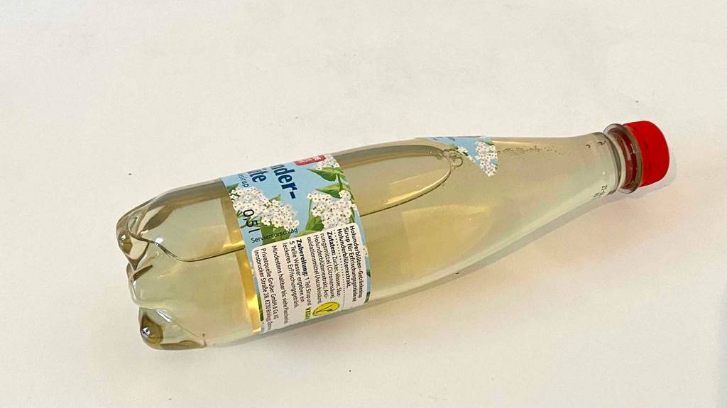 Holunderblütensirup im Test: Flasche Liegend auf einer weißen Fläche.