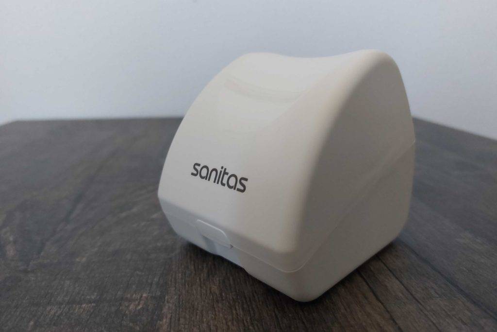 Sanitas-Blutdruckmessgerät getestet: Schutzverpackung des Messgerätes auf einer Holzoberfläche