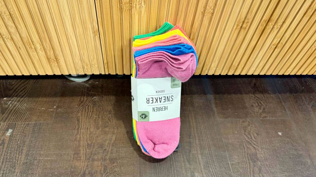 Test: Bunte-Socken mit 7 Paar im Pack enthalten sind an einer Wand angelehnt.