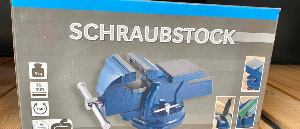 Schraubstock drehbar im Test: Ein Schraubstock in Originalverpackung in einem Regal.