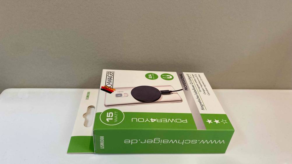 Im Test: Auf einer hellen Oberfläche liegt ein verpacktes Qi-Ladegerät.