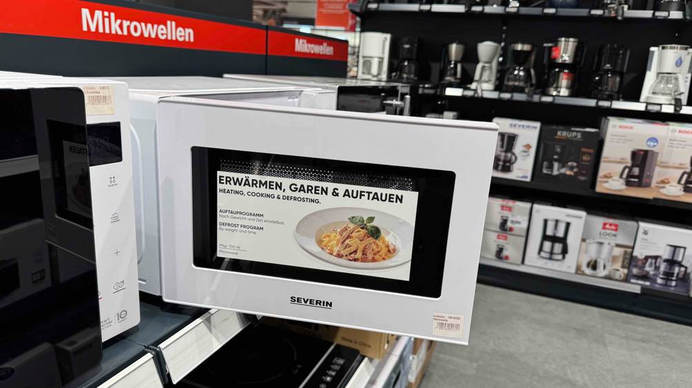 Die geöffnete Tür der getesteten Severin-Mikrowelle, worauf sich Hinweise zum Produkt befinden.