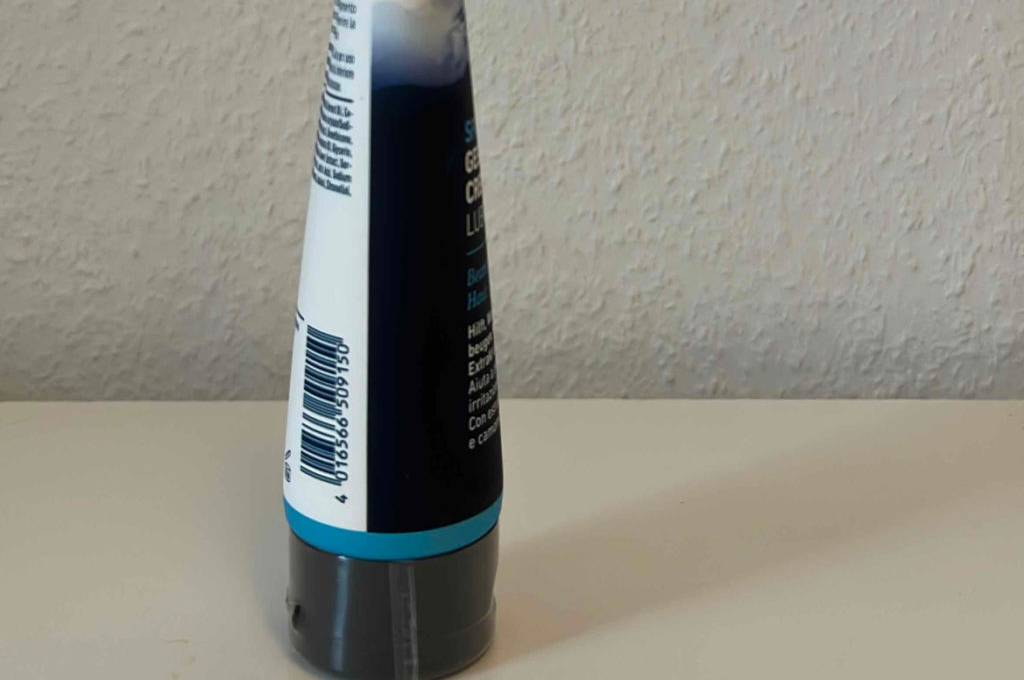Eine Tube getestete Gesäßcreme von der Seite vor einer hellen Wand.