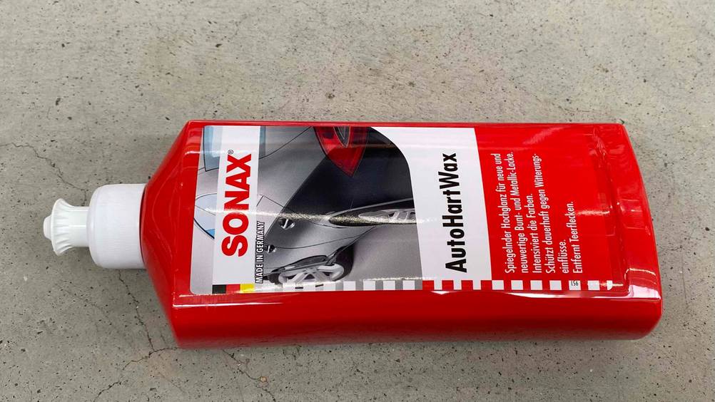 Auto-Hartwachs im Test: Eine Flasche liegt auf einem Steinboden