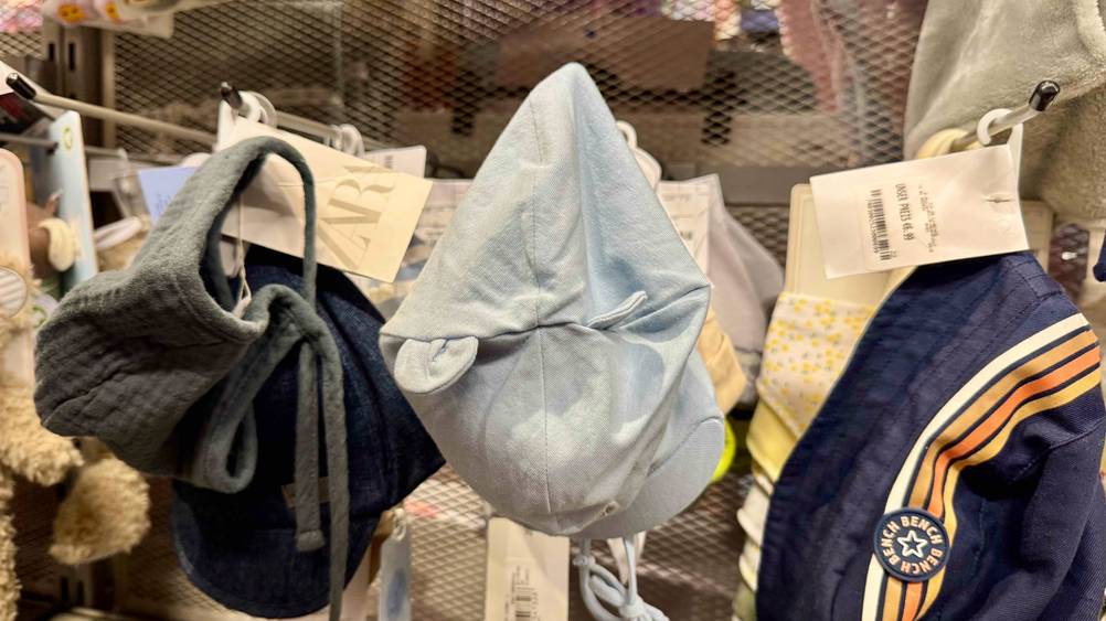 Mehrere getestete Babymütze hängen in einem Regal.