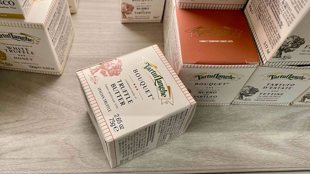 Trüffelbutter getestet: Eine Packung liegt neben anderen Produkten auf einer Holzoberfläche.