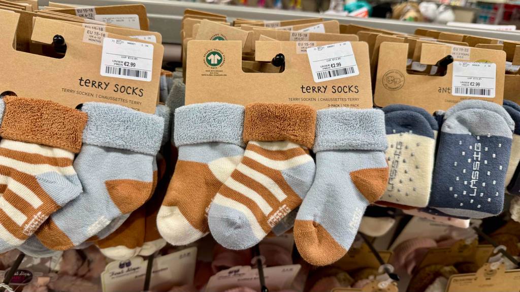 Mehrer Paar getestete Babysocken befinden sich in einem Geschäft auf Haken.