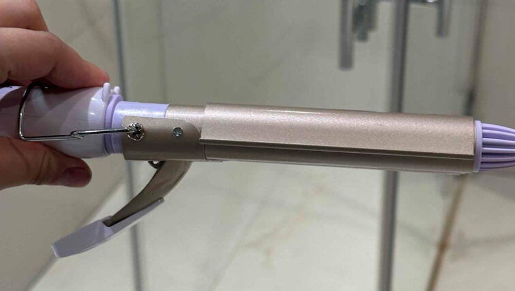 Lockenstab mit 3 Stäben im Test: ein Lockenstab mit einem einzelnen Stab wird horizontal in der Hand gehalten.