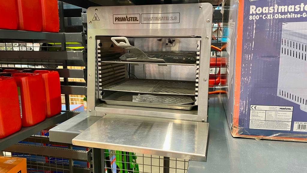 Ein getesteter Oberhitzegrill mit Ablagen, ein Blech und ein Schieber darin.