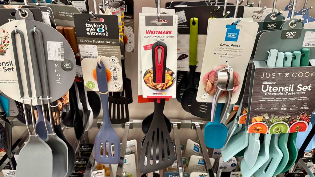 Mehrere getestete Pfannenwender hängen in einem Regal