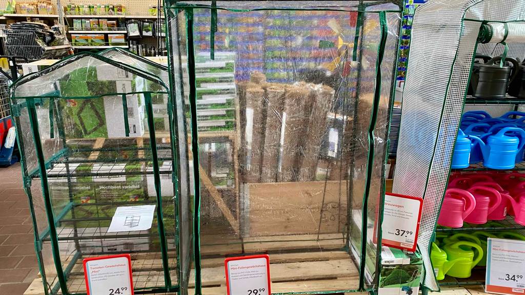 Foliengewächshaus-Test: ein Foliengewächshaus mit verschlossener Türe steht neben anderen Modellen.