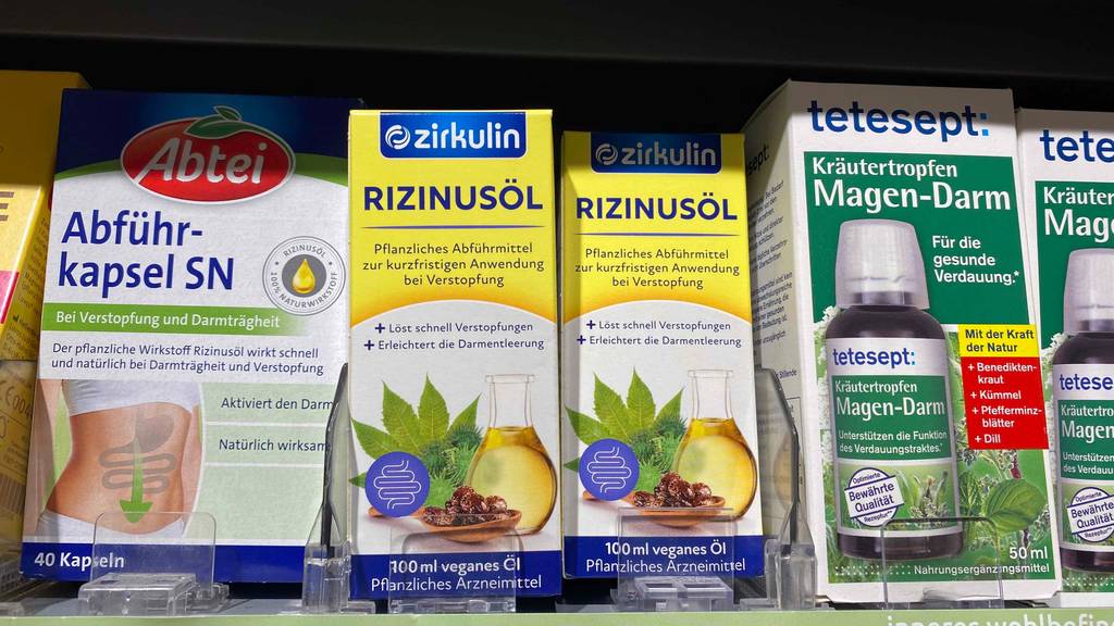 Rizinusöl im Test: zwei Packungen Rizinusöl der Marke Zirkulin stehen in einem Regal neben anderen Produkten.
