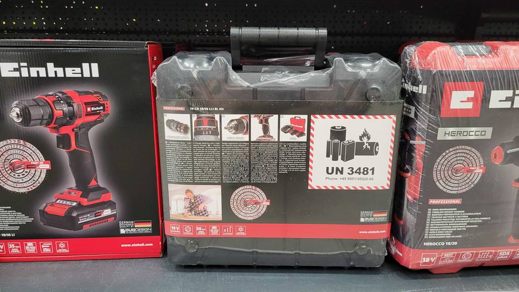 Rückseite der Verpackung des getesteten bürstenloser Akku-Schlagbohrschraubers im Fokus, die in einem Regal steht.