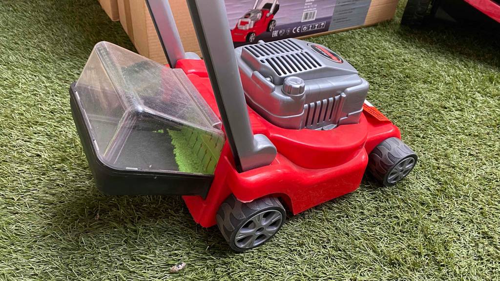 Kinder-Rasenmäher im Test: roter Kinder-Rasenmäher mit Auffangbehälter.