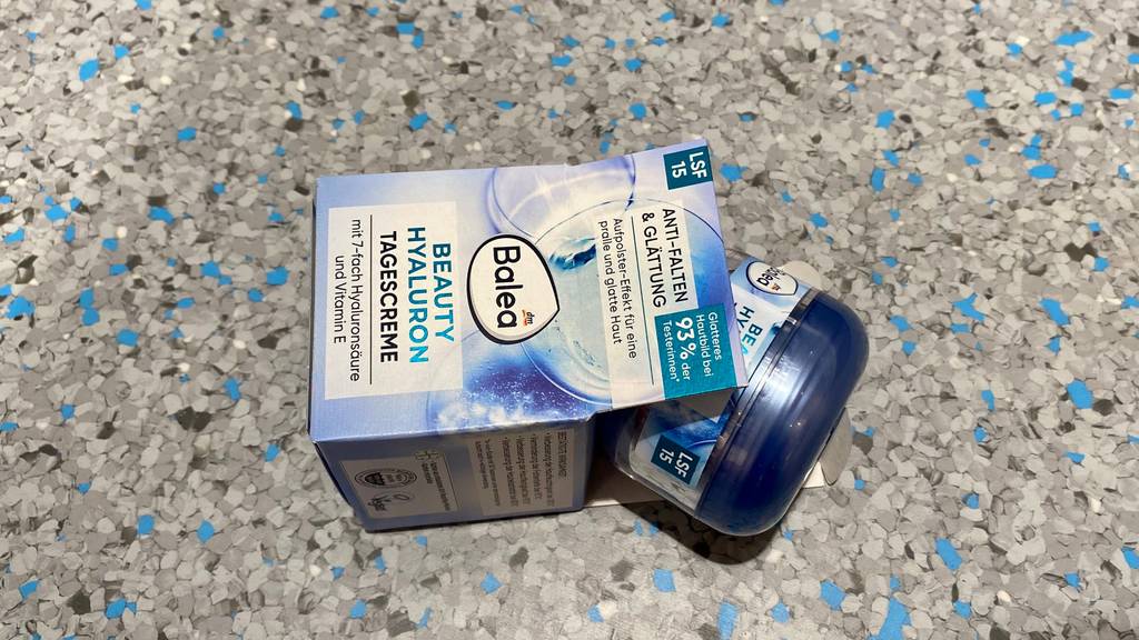 Hyaluron-Creme im Test: Verpackung und Cremetiegel herausschauend auf einer marmorierten Fläche.