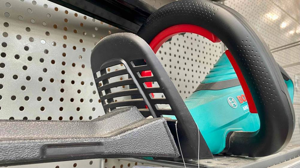 Akku-Heckenschere im Test: Akku-Heckenschere der Marke Bosch steht vor einer weißen Wand mit Löchern