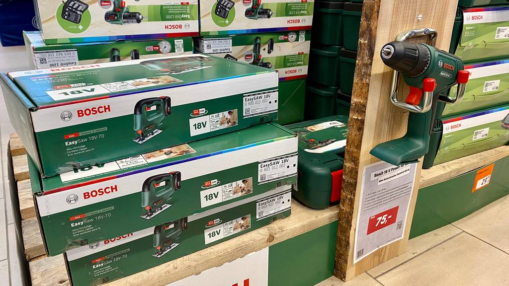 Bosch-Stichsäge getestet: Verpackungen von Bosch-Stichsäge und daneben Akkuschrauber auf einem Holzstück ausgestellt.