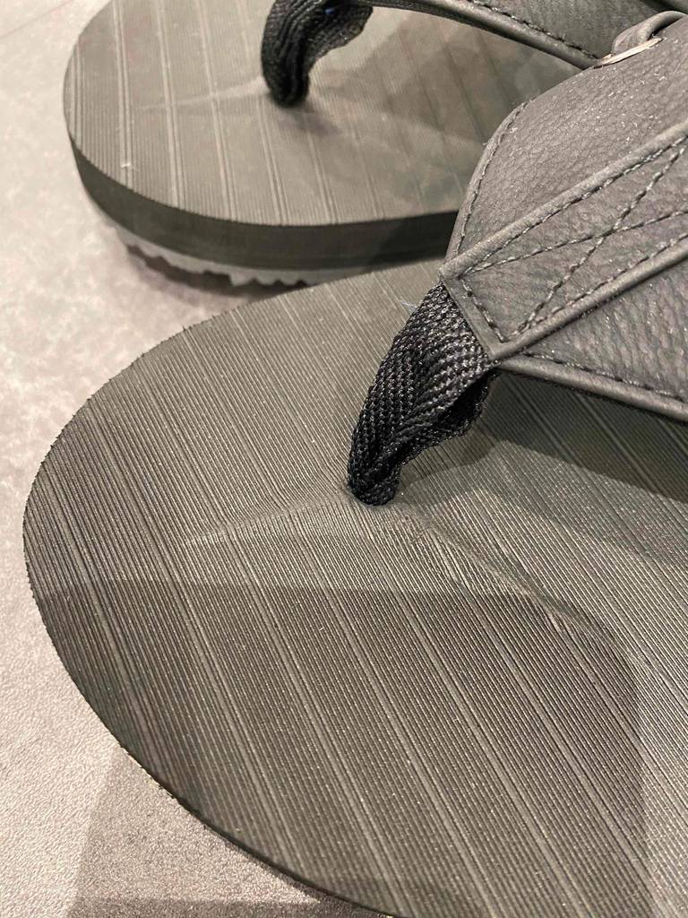 Flip-Flops-Herren getestet: Bändchen von schwarzen Flip-Flops im Fokus.