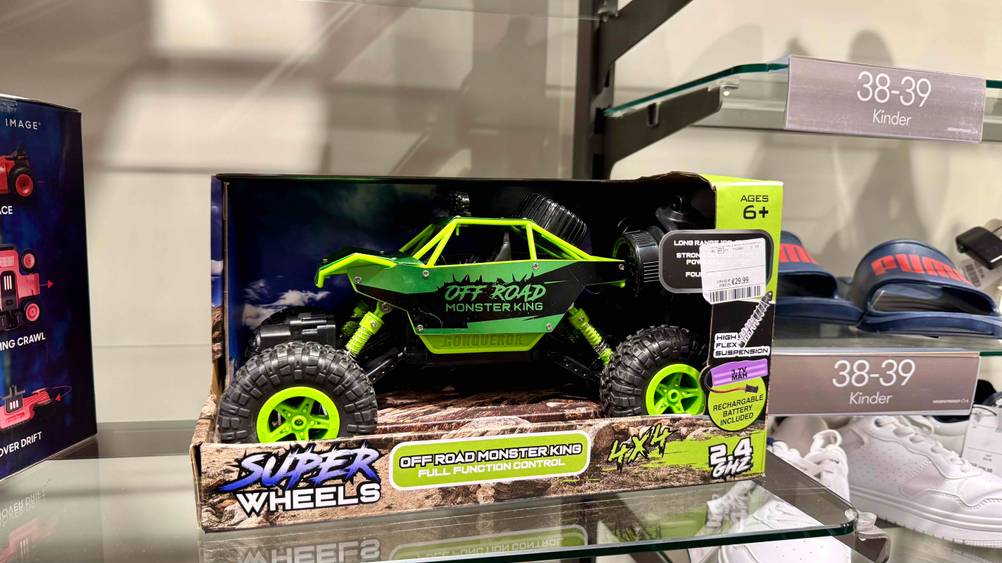 Ein getesteter Monstertruck steht in der Verpackung in einem Regal.