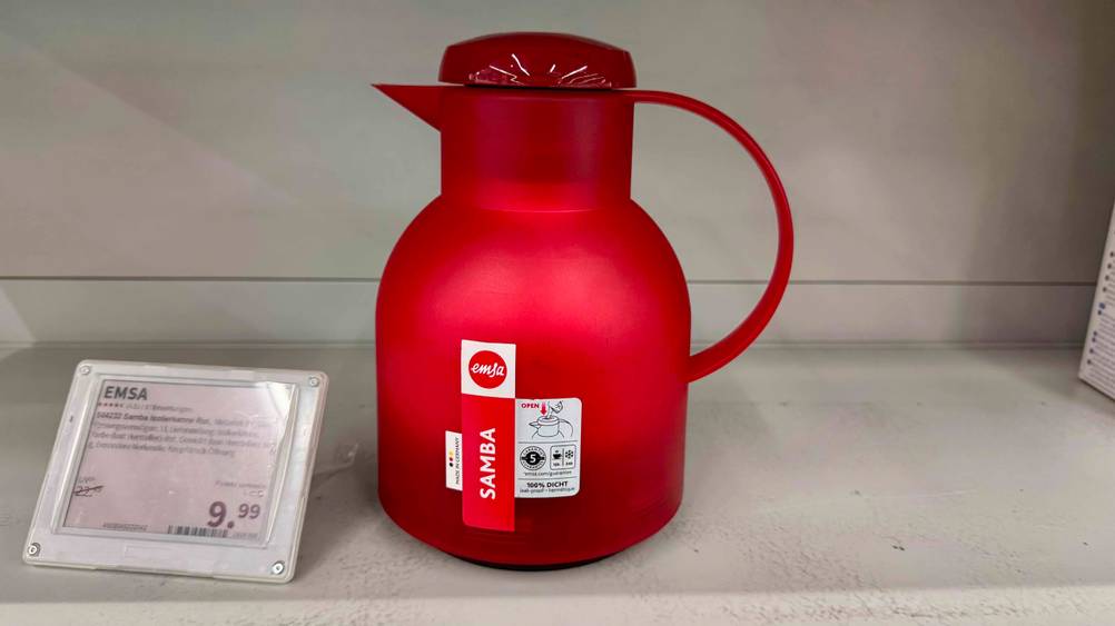 Die getestete Emsa-Isolierkanne in der Farbe Rot ist neben dem Preisschild platziert.