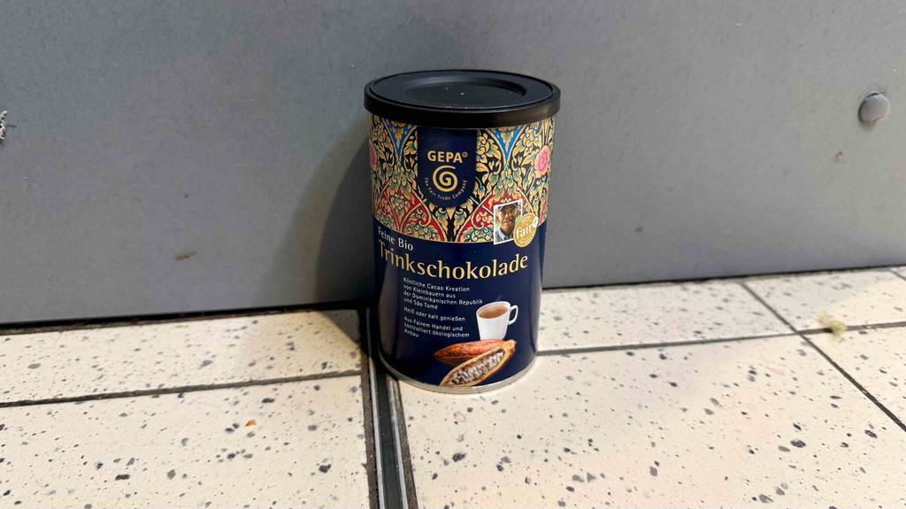 Eine getestete Bio-Trinkschokolade steht vor einer Wand.