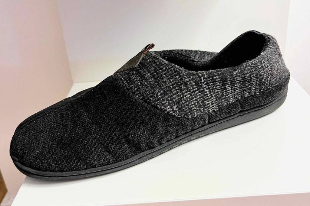 Hausschuhe Herren im Test: Ein einzelner Schuh von der Seite auf weißem Regal
