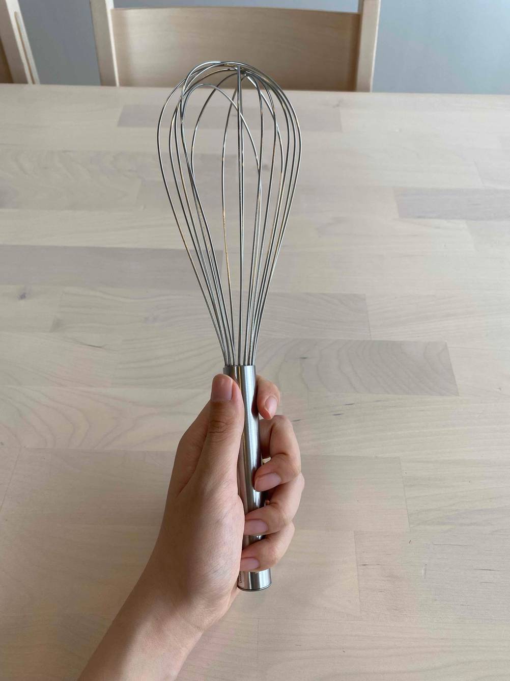 Schneebesen in der Hand.