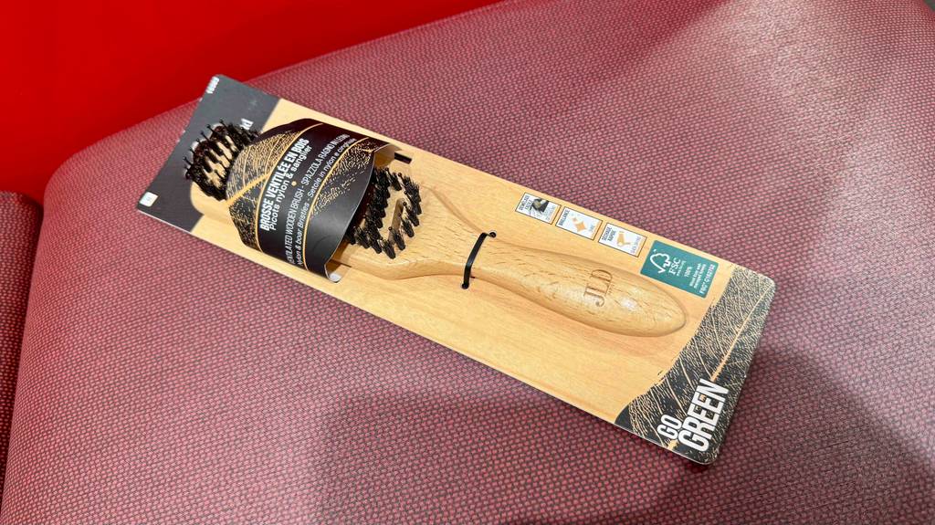 Die getestete Holz-Haarbürste liegt auf einer Sitzfläche in der Verpackung.