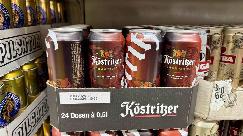Getestet: Mehrere Dosen Schwarzbier befinden sich in einem Karton neben anderen Biersorten.