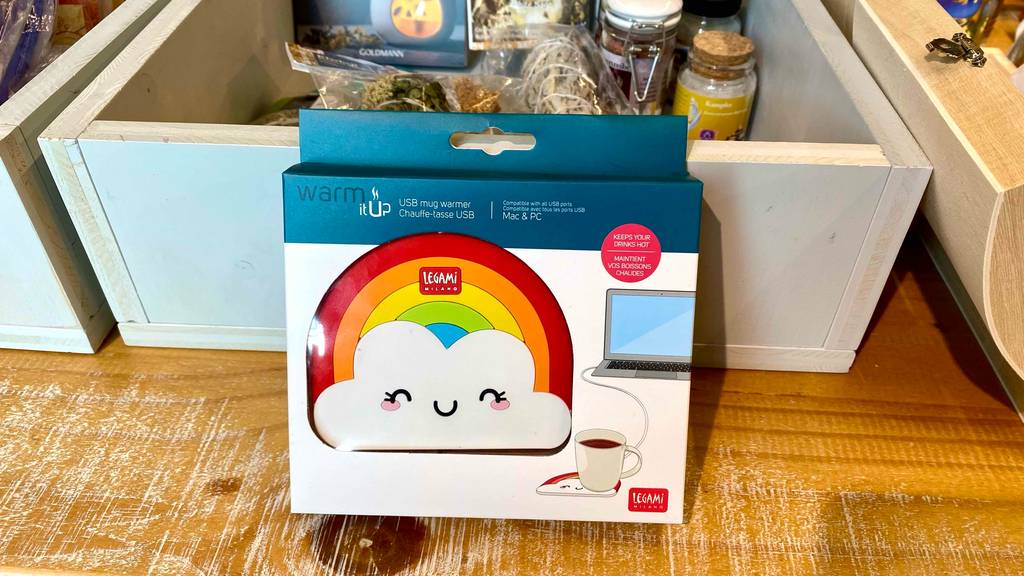 USB-Tassenwärmer getestet: ein USB-Tassenwärmer im Regenbogen-Design ist an einer Kiste angelehnt.