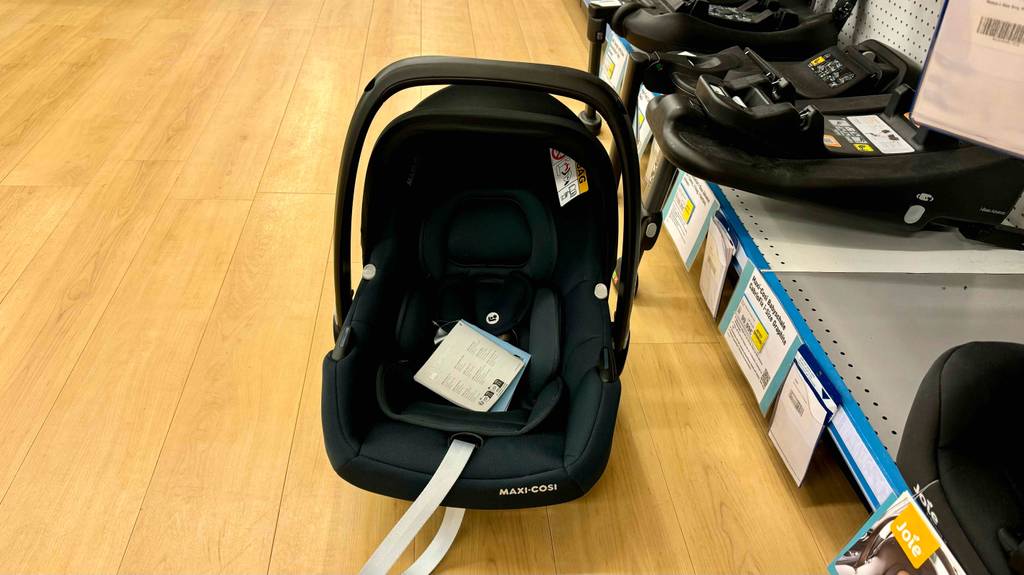 Frontaufnahme einer getesteten Maxi-Cosi-Babyschale mit Broschüre darin.