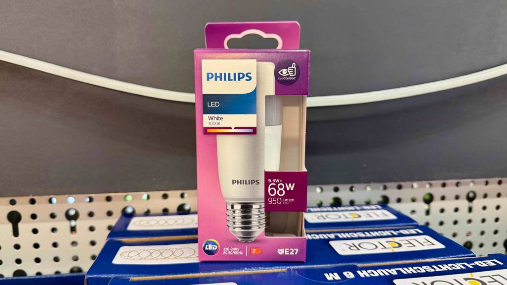 Ein pinke Verpackung mit einer getesteten dimmbaren E27-LED-Leuchte steht auf einer blauen Verpackung für Lichtschalter.
