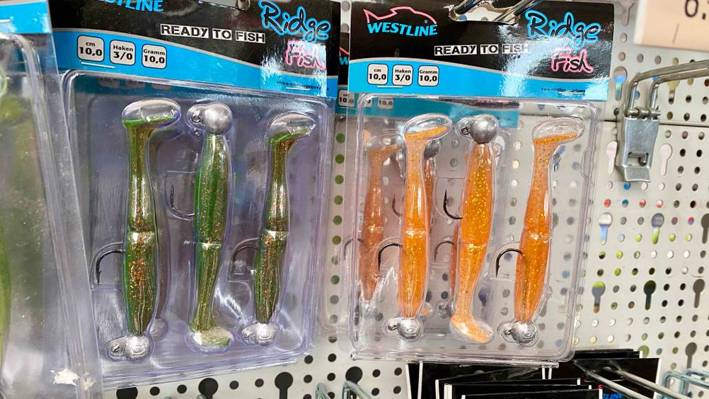 Im Test: Mehrere verpackte Gummifische hängen in einem Regal.