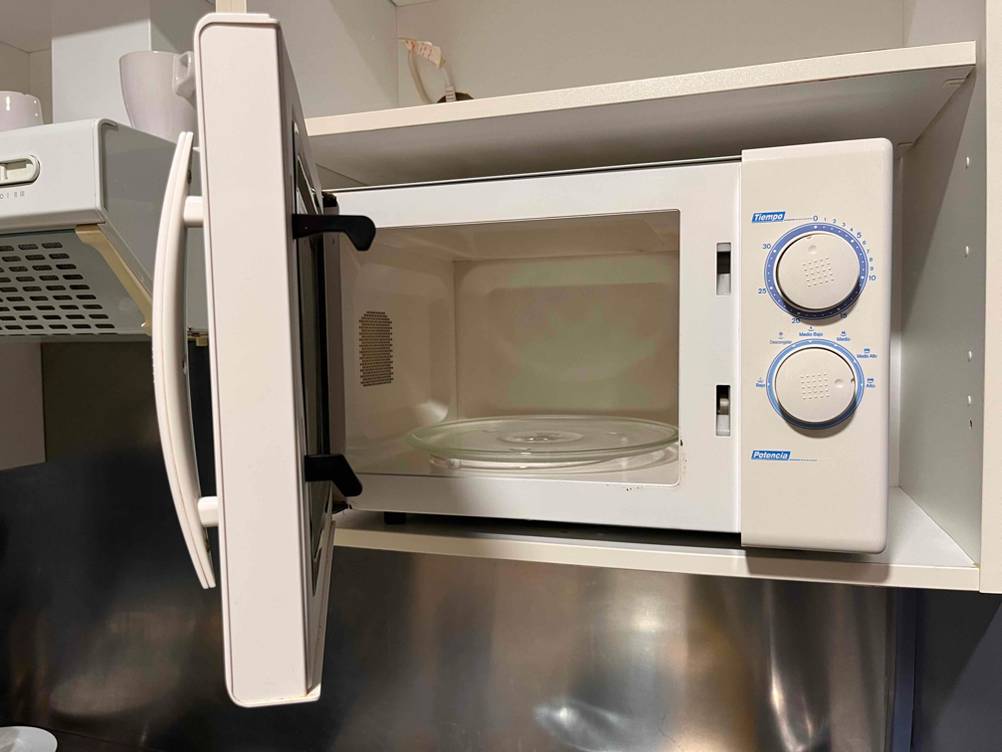 Bei der getesteten Mikrowelle ohne Grill steht die Tür offen, das Gerät steht in einem Regal