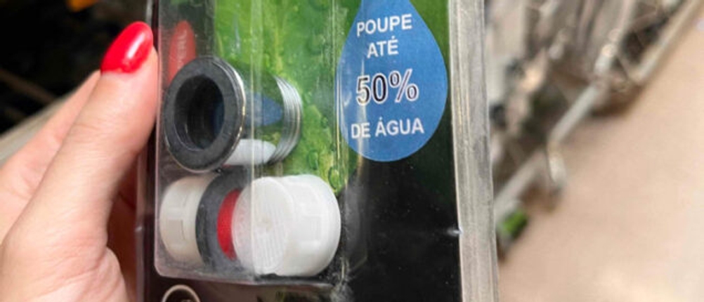 Wasserfilter-Wasserhahn-Test: Verpackung von Wasserfilter für den Wasserhahn von der Vorderseite in der Hand vor einem Regal.