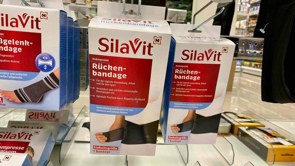 Rückenbandage getestet: mehrere Verpackungen von Rückenbandagen hängen in einem Regal.
