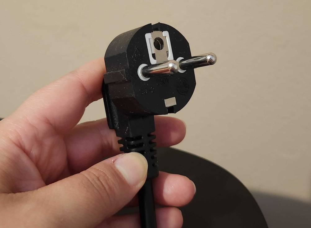 Der Netzstecker der getesteten Heißluftfritteuse mit Grillfunktion wird in der Hand gehalten.