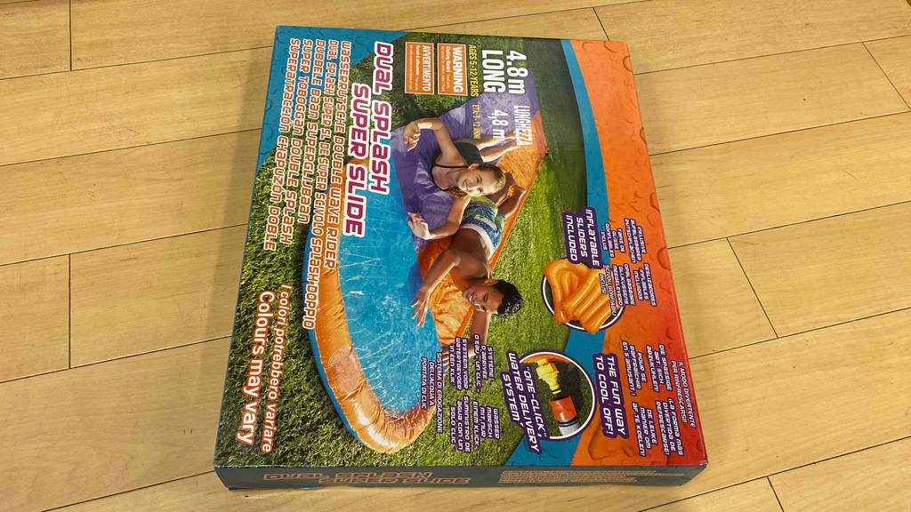 Im Test: Auf einem Holzboden liegt eine Wasserrutsche in Originalverpackung.