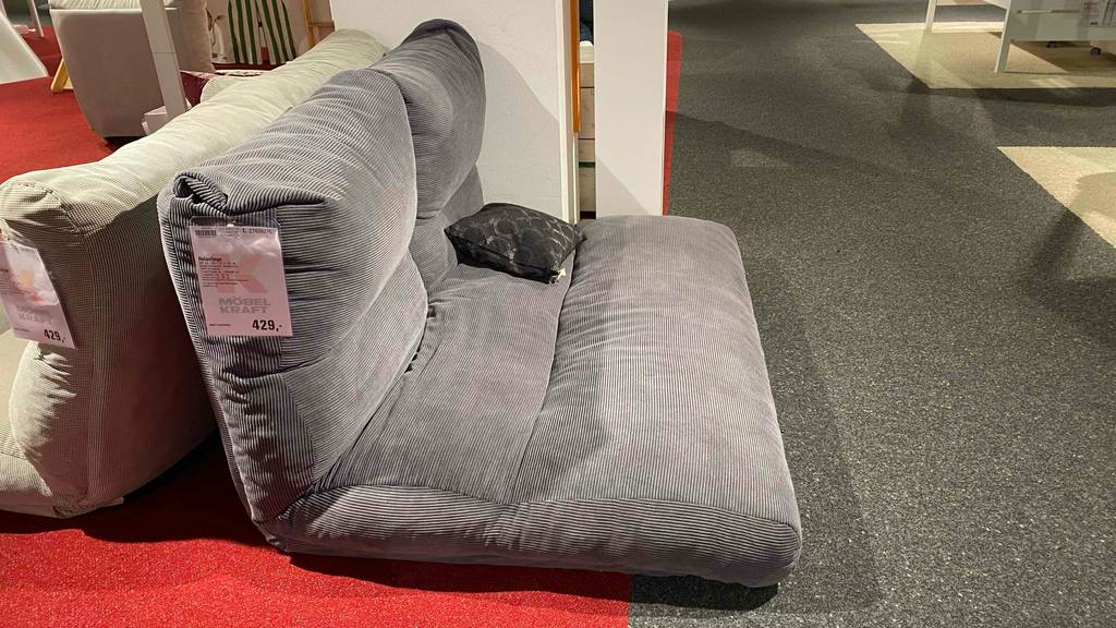 Relaxliege getestet: eine graue Relaxliege von der Seite mit einem Preisschild darauf.