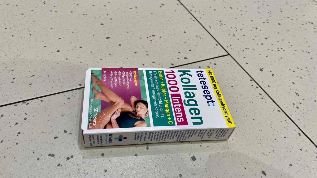 Kollagen-Kapseln im Test: Packung von Tetesept Kollagen 10000 Intens liegen auf einem Fliesenboden.