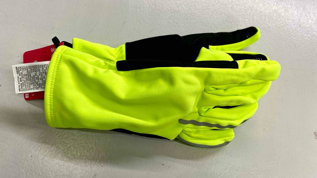Fahrradhandschuh für den Winter im Test: zwei Neon-gelbe Fahrradhandschuhe mit schwarzen Details liegend.